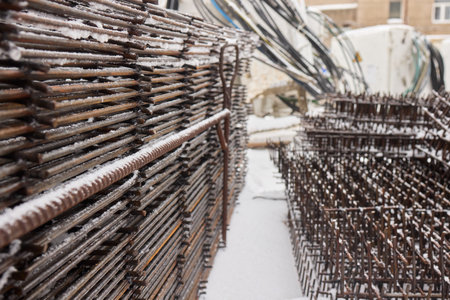 A construction site with piles of organized reinforced steel bars being prepared for useの写真素材