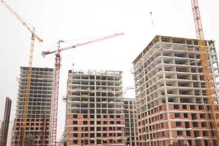 A bustling Construction Site showcasing Cranes, Building Framework, and full activity all aroundの写真素材