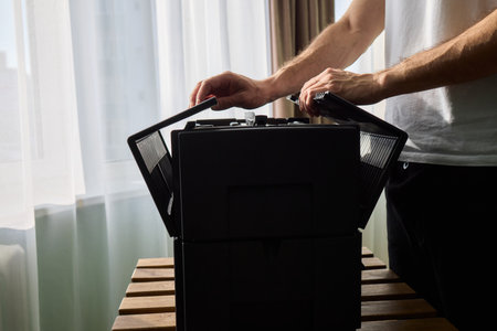 A person diligently assembling a contemporary black cooling device with precision and focus