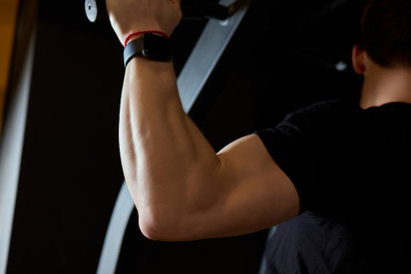 An athlete performs pullups in a gym, demonstrating strength and skill while focusing on fitness