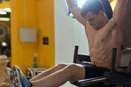 A young man confidently doing dips in a modern gym, showing dedication to his fitness goals