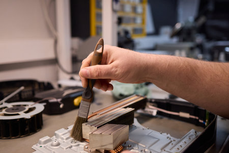 Skilled Hands Engaged in Repairing Electronic Devices Using a Variety of Specialized Tools