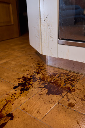 A situation where a liquid has been accidentally spilled onto the kitchen floor surfaceの写真素材