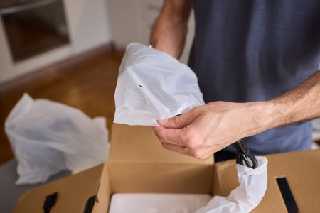 Unboxing a stylish, modern black kettle designed for use in a bright, contemporary kitchen space