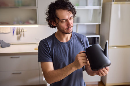 Unboxing a stylish, modern black kettle designed for use in a bright, contemporary kitchen spaceの写真素材