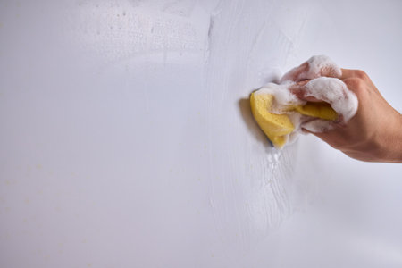 Cleaning the Kitchen Wall effectively with a Sponge and some good detergent for hygieneの写真素材