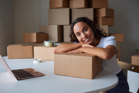Happy woman unpacking container at home, opening carton box, looking inside package. Smiling...