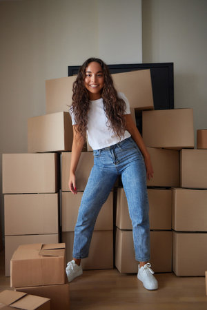 Young beautiful hispanic woman smiling confident packing cardboard box at new home.