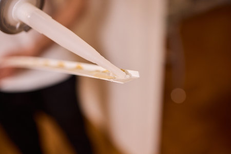 Applying adhesive to flexible material demands skill for a lasting, strong bondの写真素材