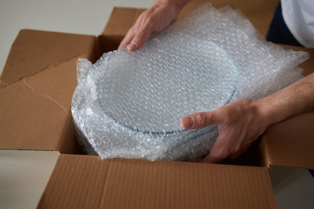 a man collects plates in boxes for moving.の写真素材
