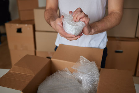 a man collects plates in boxes for moving.の写真素材