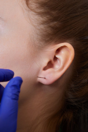 piercings on an ear. Conch and helix piercings close up.の写真素材