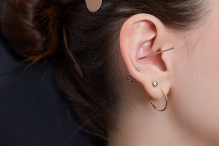 piercings on an ear. Conch and helix piercings close up.の写真素材