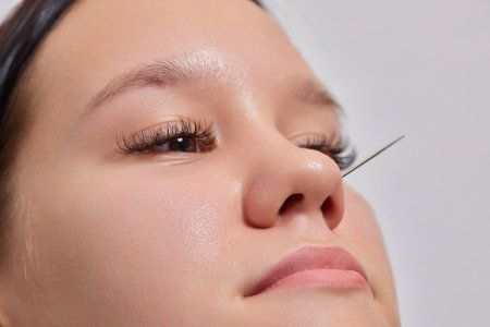 Closeup of a young womans visage with piercing septum hanging from her nose.の写真素材