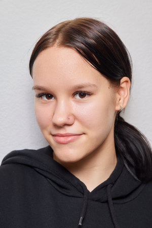 Closeup of a young womans visage with piercing septum hanging from her nose.