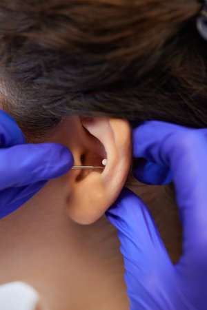 piercings on an ear. Conch and helix piercings close up.の写真素材