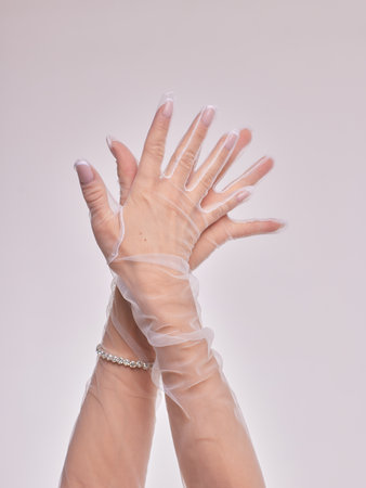 Female hands in transparent black gloves on dress background.の写真素材