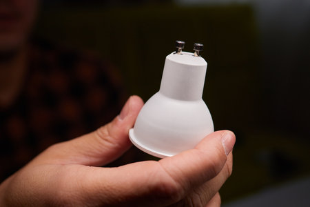 Hand changing a regular light bulb for LED at home