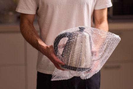 Unboxing a stylish, modern kettle designed for use in a bright, contemporary kitchen spaceの写真素材