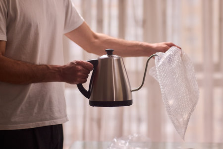 Unboxing a stylish, modern kettle designed for use in a bright, contemporary kitchen spaceの写真素材