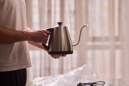 Unboxing a stylish, modern kettle designed for use in a bright, contemporary kitchen spaceの写真素材