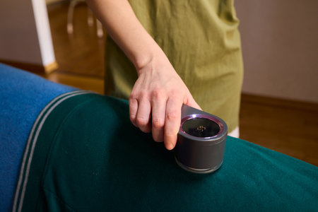 Effectively Removing Lint from a Beautiful Sweater Using a Handy and Useful Lint Roller Toolの写真素材