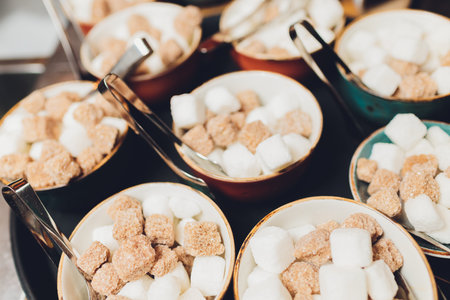 Bowl with white and brown sugar cubes and tongs.の写真素材