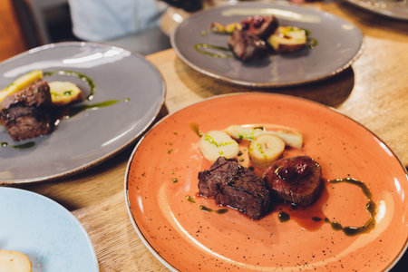 Beef spare ribs on a white plate beef tenderloin, root vegetables, cherry almonds.