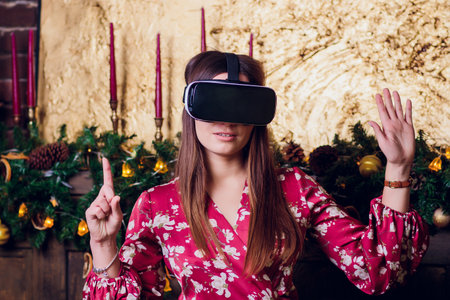 Young woman using Virtual Reality Glasses. Virtual reality mask. VR. Retro loft Christmas background...