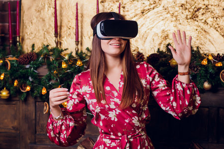 Young woman using Virtual Reality Glasses. Virtual reality mask. VR. Retro loft Christmas background...