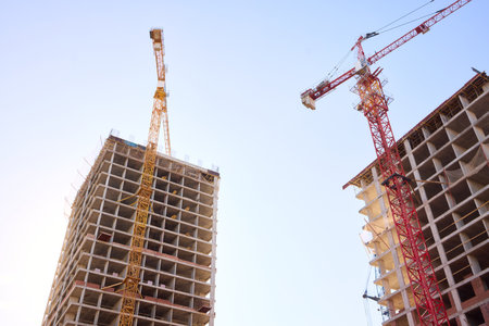 A bustling Construction Site showcasing Cranes, Building Framework, and full activity all aroundの写真素材