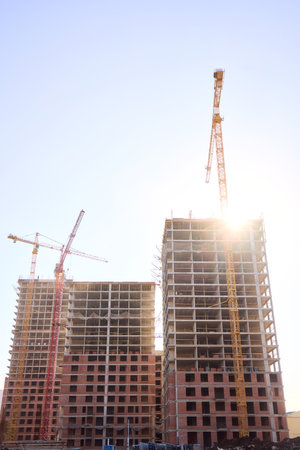 A bustling Construction Site showcasing Cranes, Building Framework, and full activity all aroundの写真素材