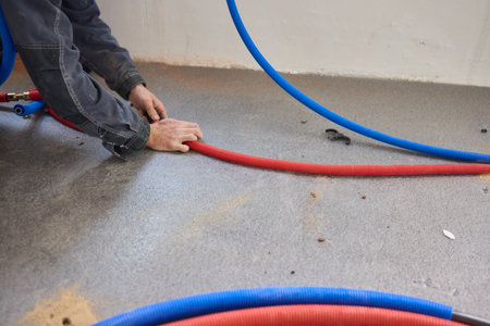 A Skilled Plumber Installing Color Coded Piping Throughout a Large Construction Projectの写真素材