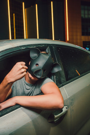 A mysterious individual wearing a pig mask stands under vibrant neon lights, captivating allの写真素材