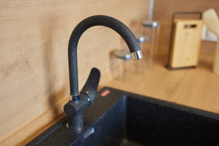 A faucet on a bathroom sink with a soap bottleの写真素材