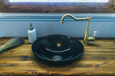 A faucet on a bathroom sink with a soap bottleの写真素材
