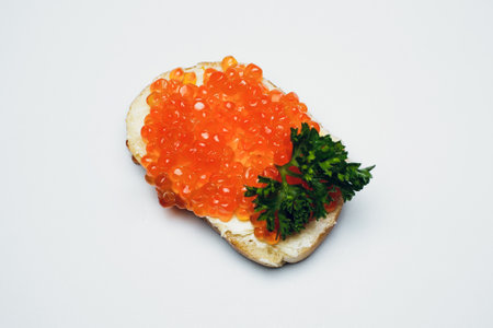 Savor delicious bread with red caviar and fresh parsley, perfect for any occasionの写真素材