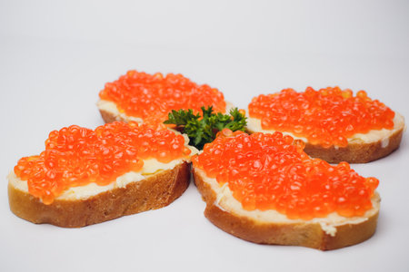 Savor delicious bread with red caviar and fresh parsley, perfect for any occasionの写真素材