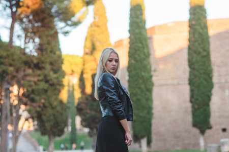 A Stylish Woman Taking Time to Relax in a Beautiful Historic Roman Landscape Settingの写真素材