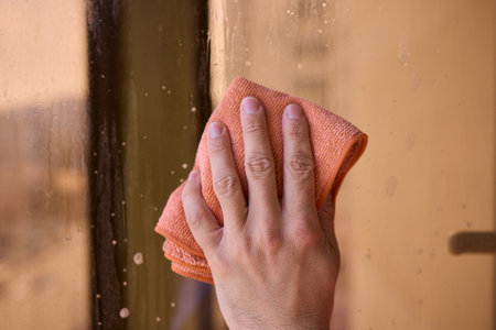 A man thoroughly cleaning a window while enjoying a stunning view of the bustling cityscape