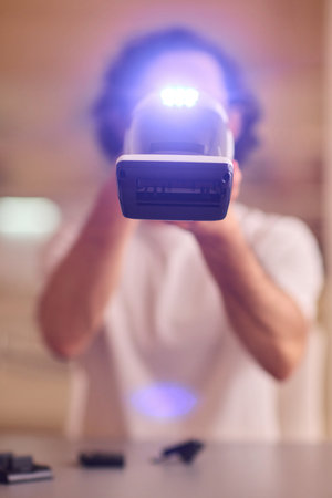 A man confidently holds a flashlight in a modern setting, showcasing thrilling action
