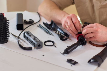 Hands of skilled workers diligently engaged in the intricate repair of mechanical devicesの写真素材
