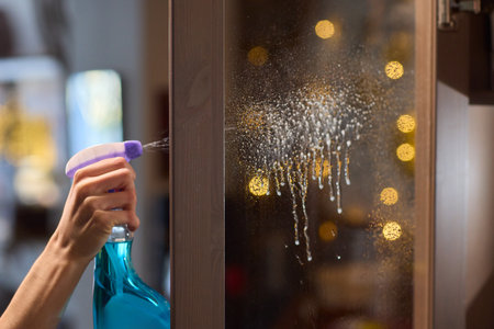 Cleaning a glass surface effectively with a spray bottle to achieve a clear, shiny finishの写真素材