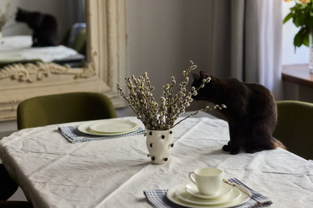 A Playful Black Cat at a Beautifully Crafted Dinner Table Setting That Captures Charm