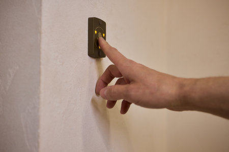 A Close Up Image of a Hand Passionately Pressing the Elevator Button in a Modern Building