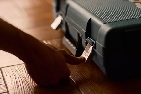 Hands skillfully opening a professional tool case designed specifically for high-quality equipmentの写真素材
