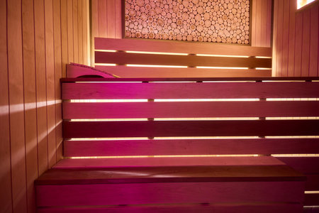 Experience the Cozy Wooden Sauna Interior Equipped with Inviting Warm Lighting and Ambianceの写真素材