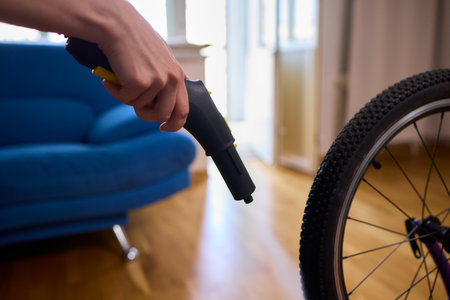 Effectively Cleaning a Bicycle Using a Vacuum Cleaner in a Contemporary Living Room Spaceの写真素材