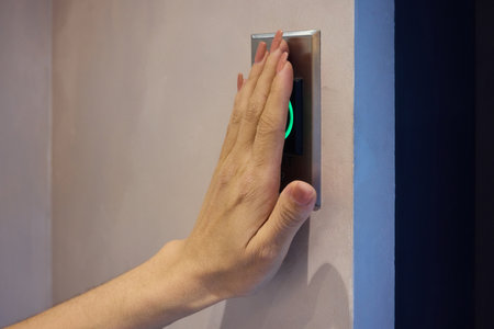 Hand Pressing a Modern Elevator Button That Features a Green Light Indicator for Operation