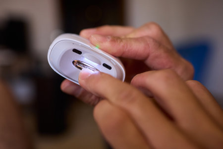 Close-up of an electric nail clipper in hand, modern personal care technology, highlighting compact...
